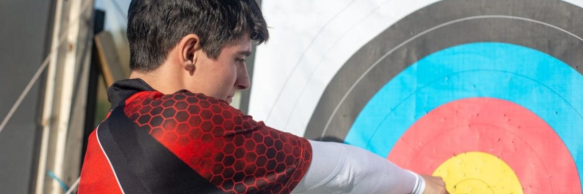 Focused young archer hitting the bullseye with precision outdoors.